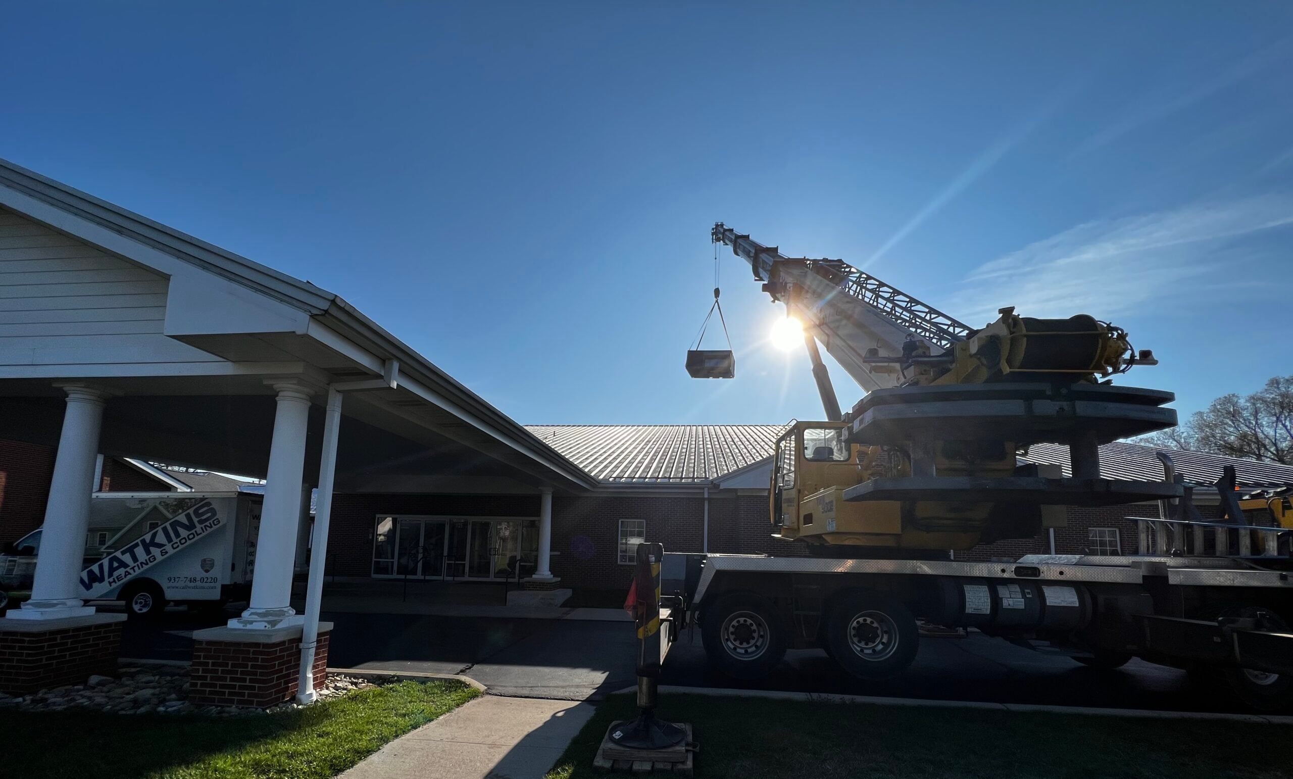 Watkins commercial hvac team installing rooftop air conditioner with crane